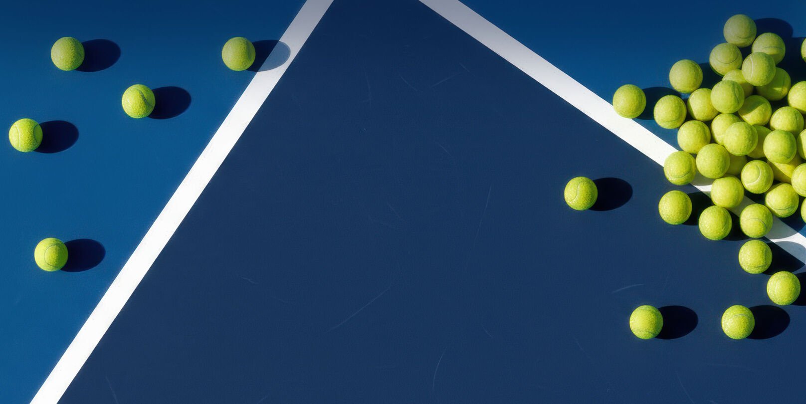 Tennis balls laying on a tennis court.