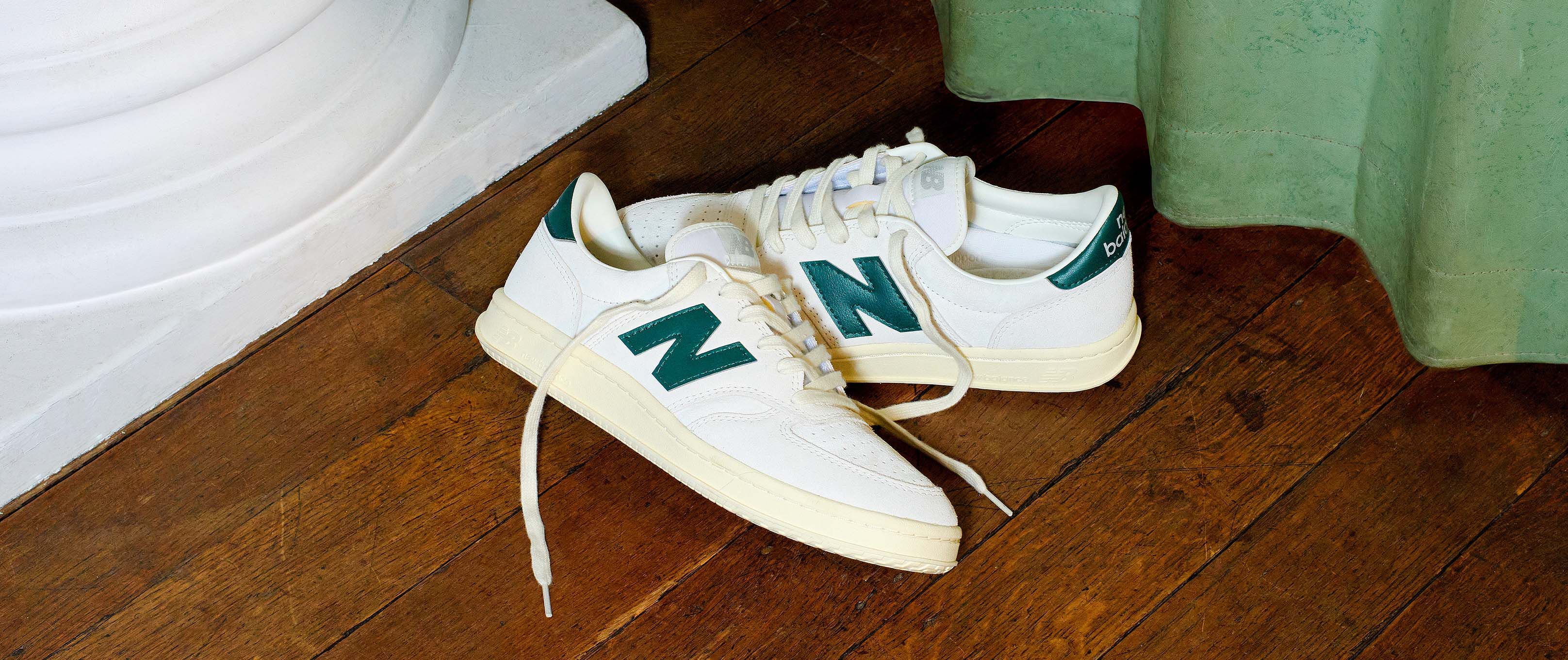 T500 shoes on a wooden floor with a green curtain in the background