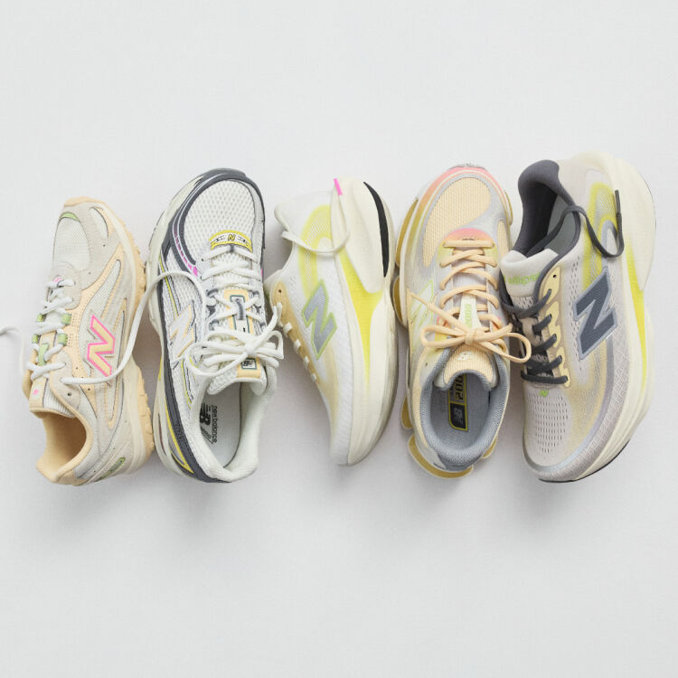 A pair of New Balance Made in UK sneakers in a brown textured studio environment. 