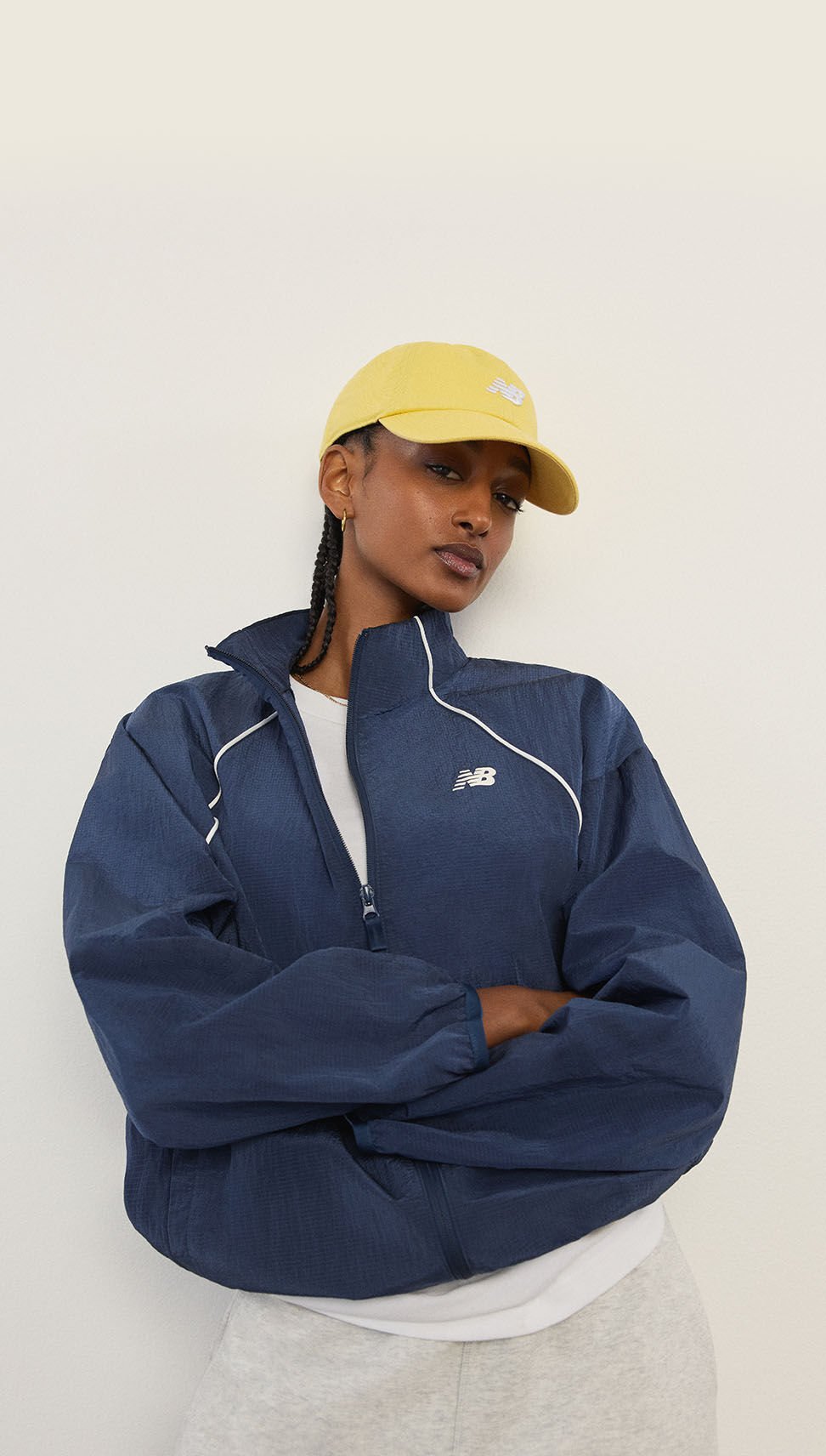 A woman standing in front of a white wall.