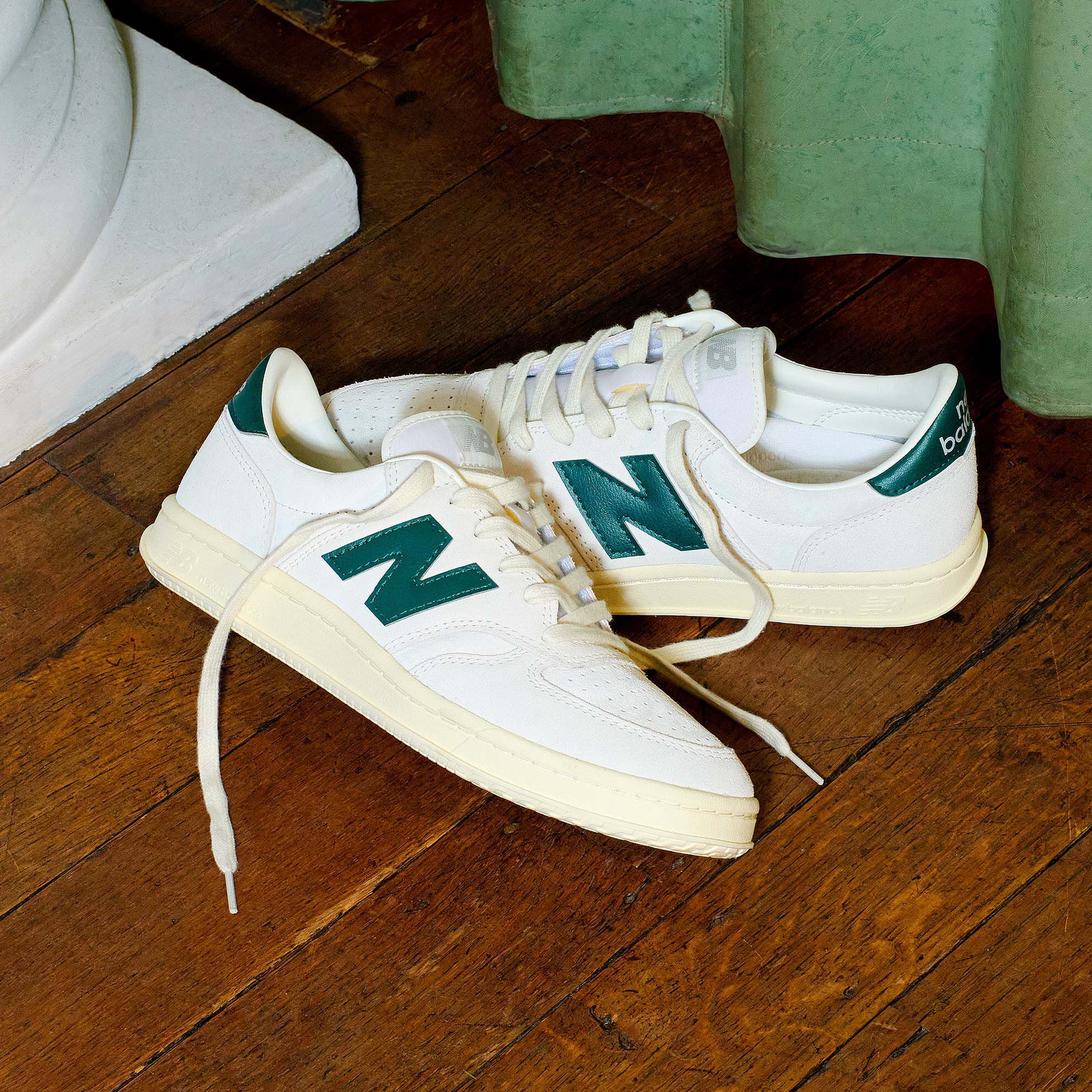 T500 shoes on a wooden floor with a green curtain in the background